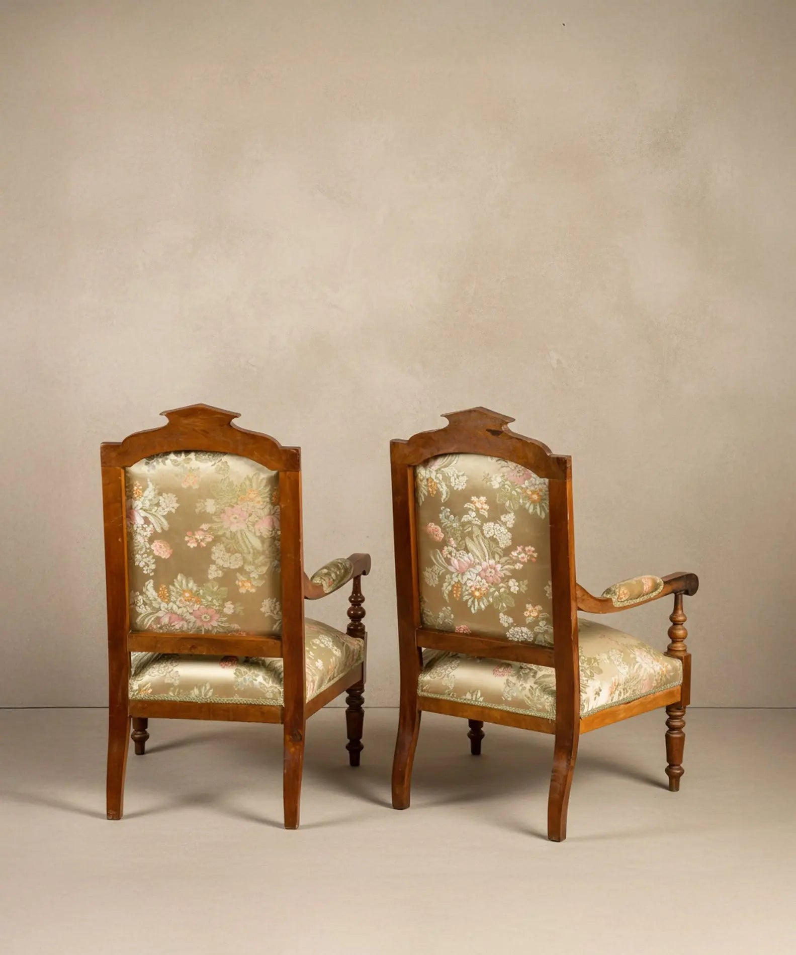 Vista posterior de la estructura de madera y tapizado de la pareja de sillones de época.