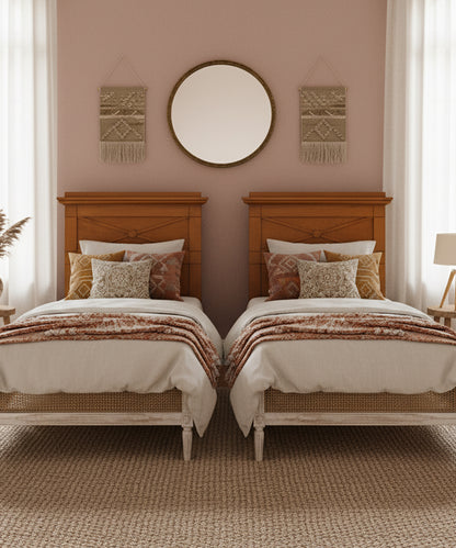 Habitación doble con dos camas individuales y cabeceros de roble Biedermeier en un ambiente bohemio con paredes rosas.
