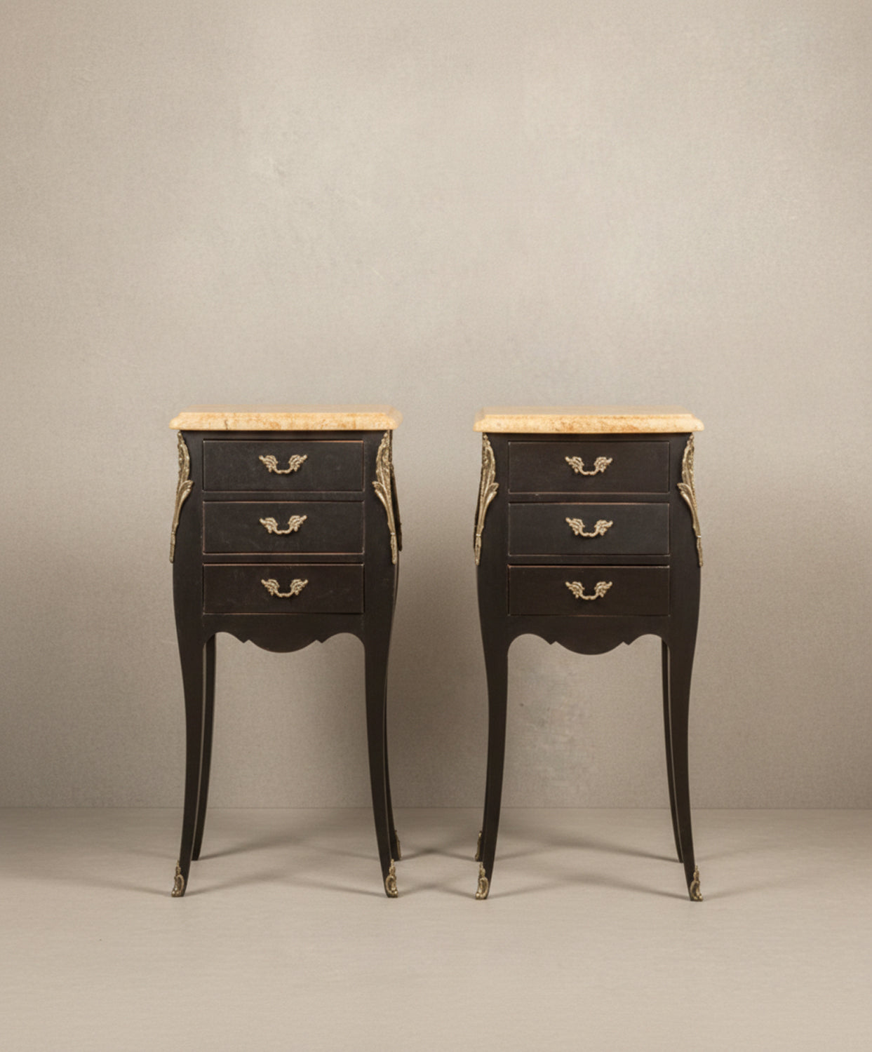 Pareja de mesillas de noche francesas estilo Luis XV en color negro mate con tres cajones y sobres de mármol.