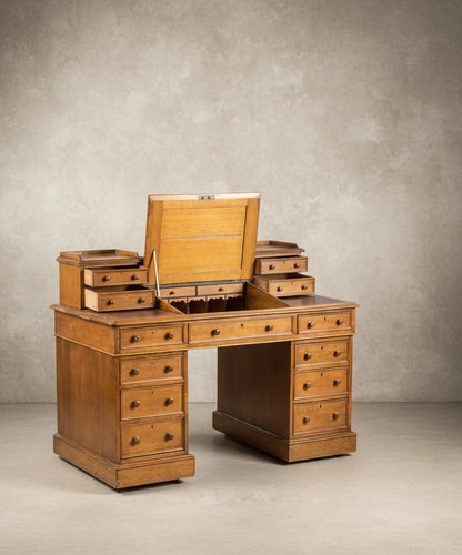 Escritorio antiguo tipo Dickens de roble con cajones de los pedestales abiertos mostrando construcción artesanal.