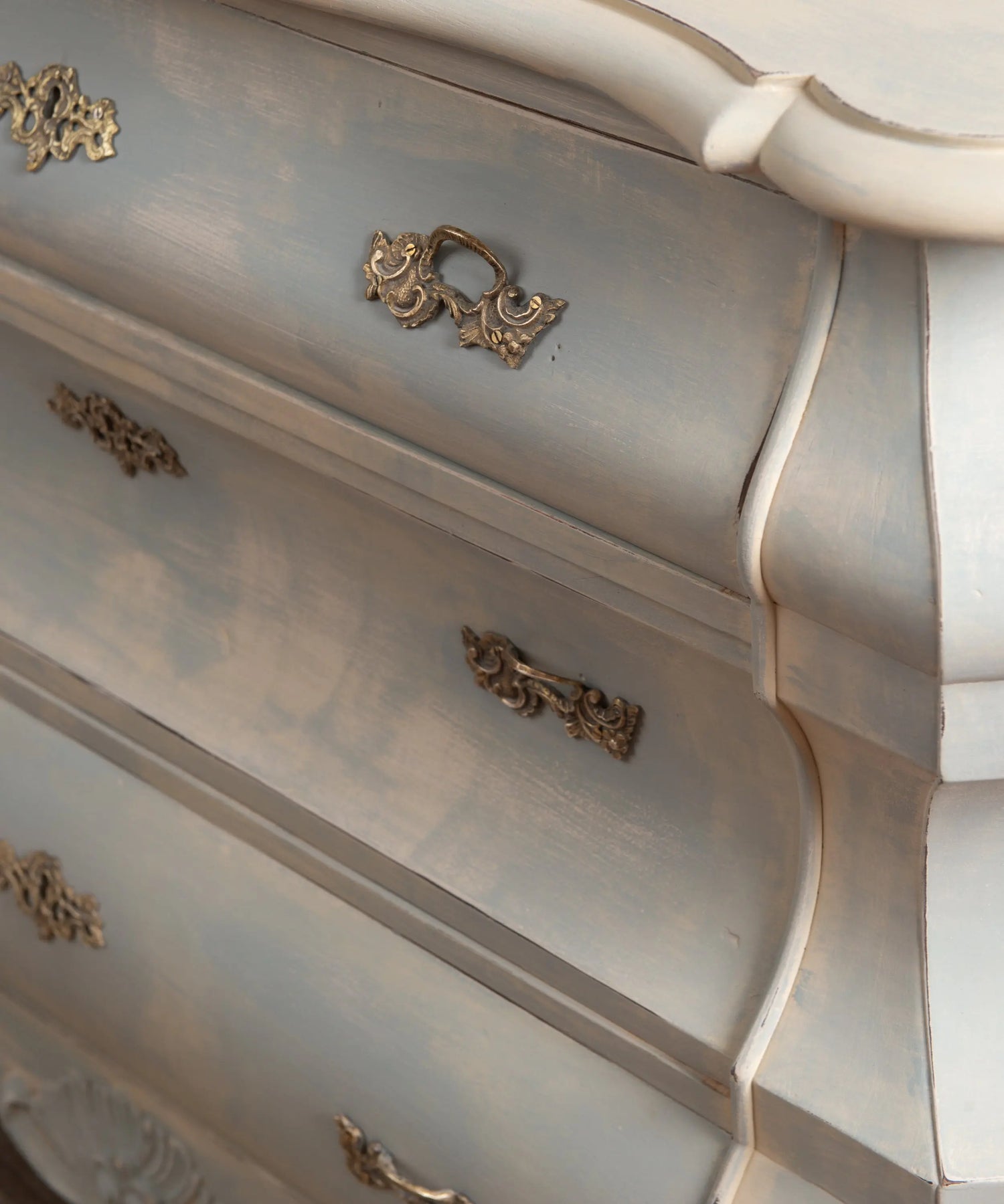 Primer plano del acabado decapé difuminado efecto nube en azul empolvado sobre cómoda vintage.