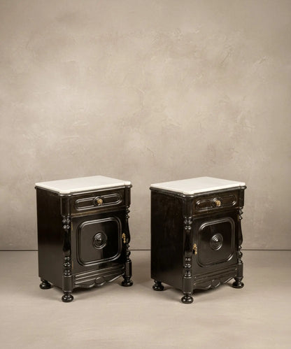 Vista lateral en ángulo que resalta las columnas torneadas y el brillo del mármol superior de las mesitas vintage.