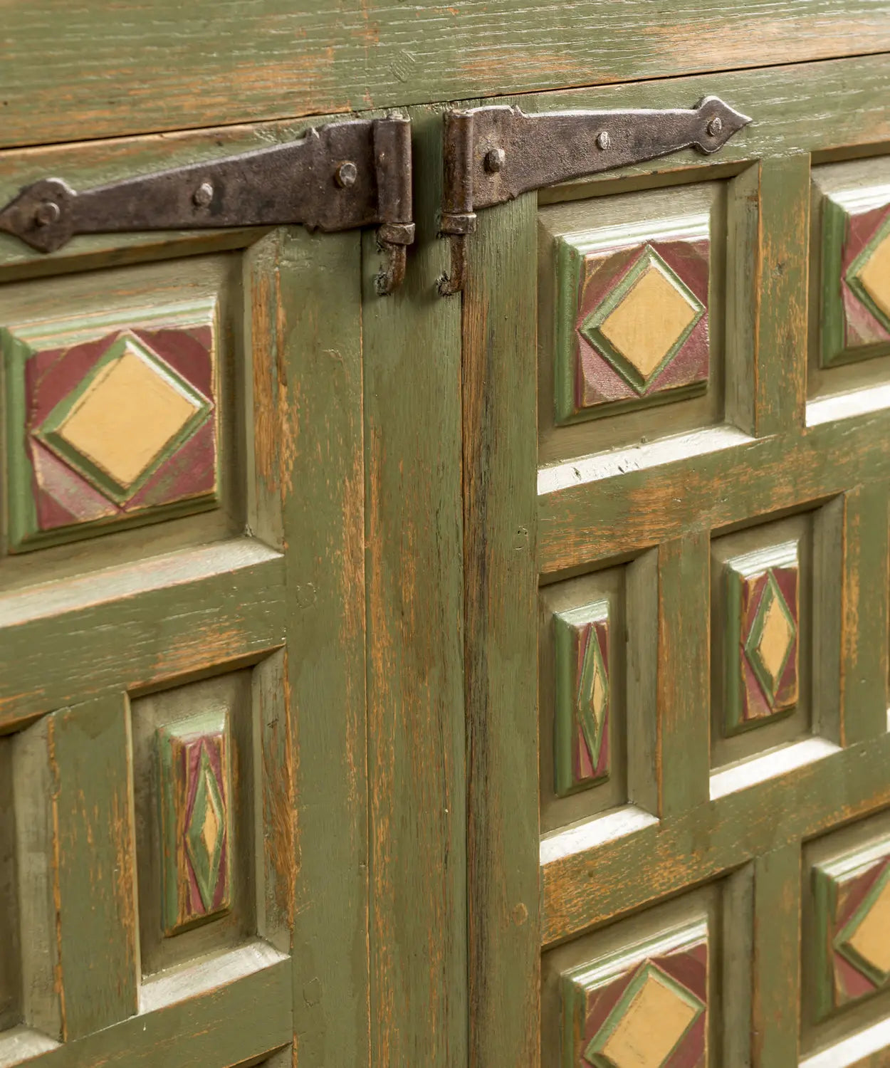  Detalle de la textura y acabado artesanal del aparador bajo luz natural, resaltando los tonos ocres y la forja artesana.