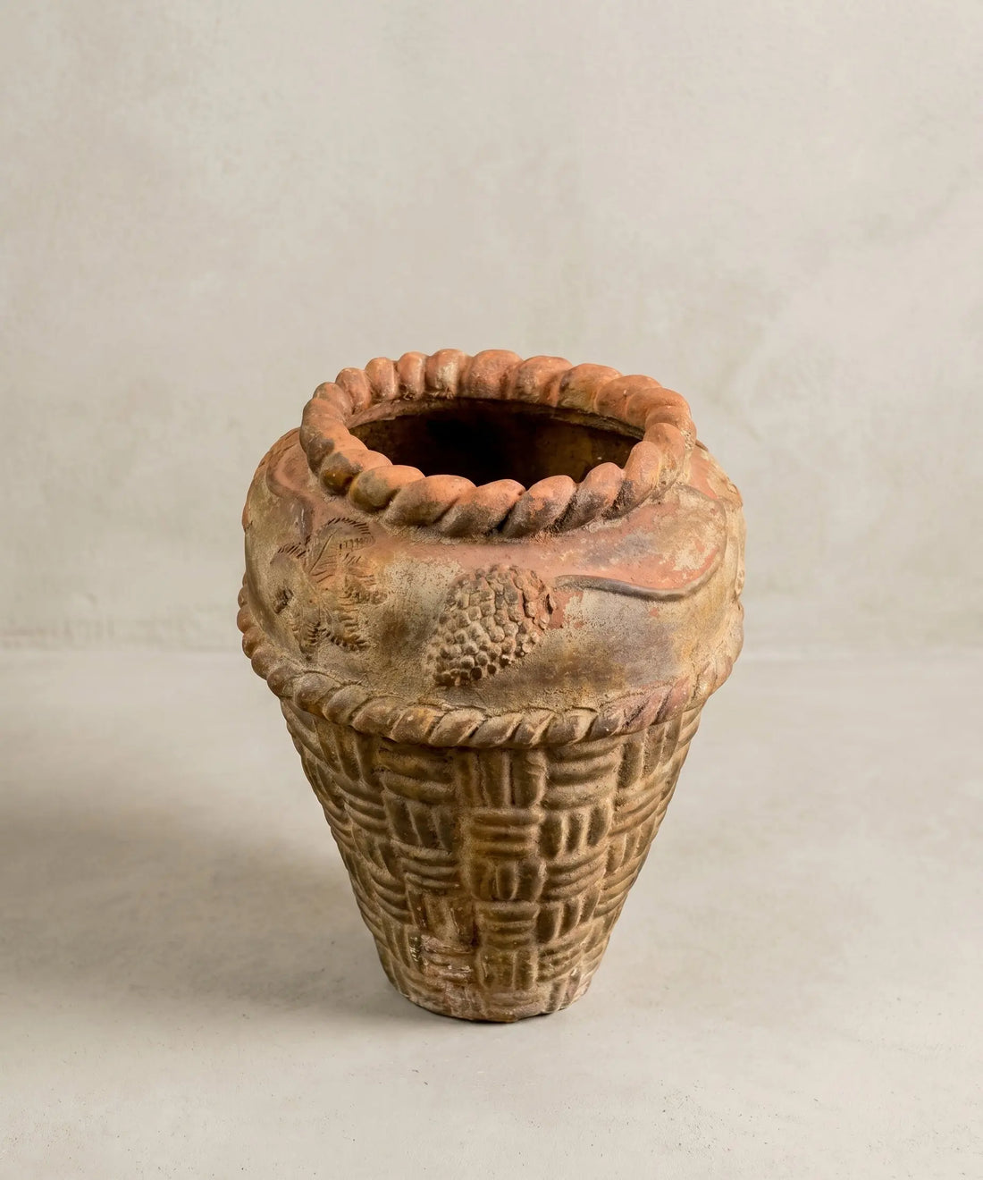 Macetero antiguo de terracota con relieve de cestería y motivos florales