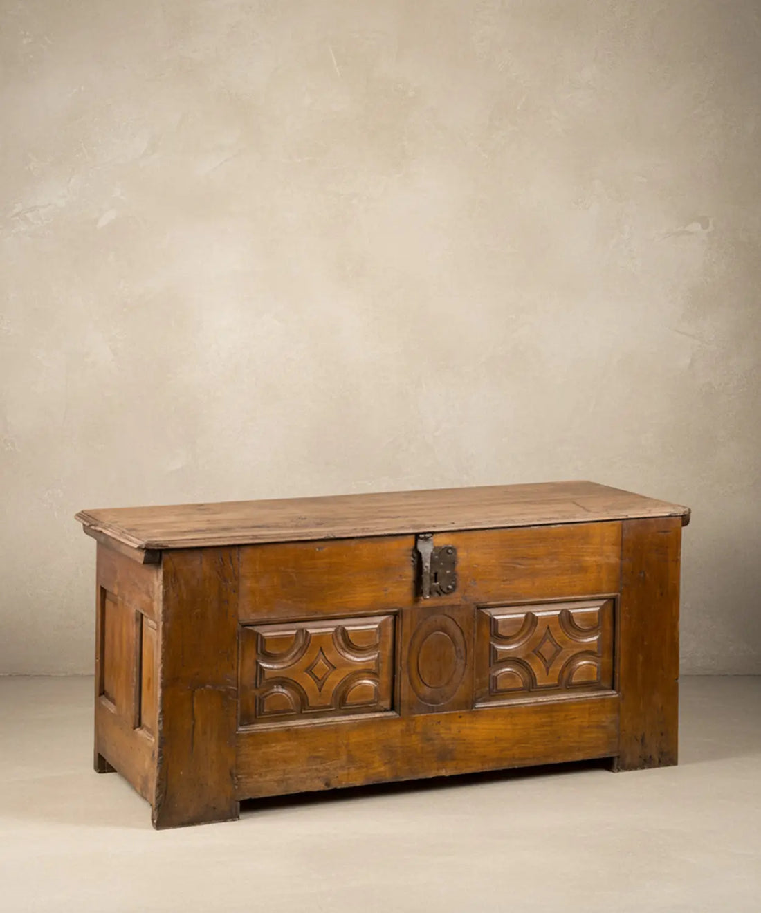 Arcón antiguo español de madera tallada con medallón central y herrajes de forja