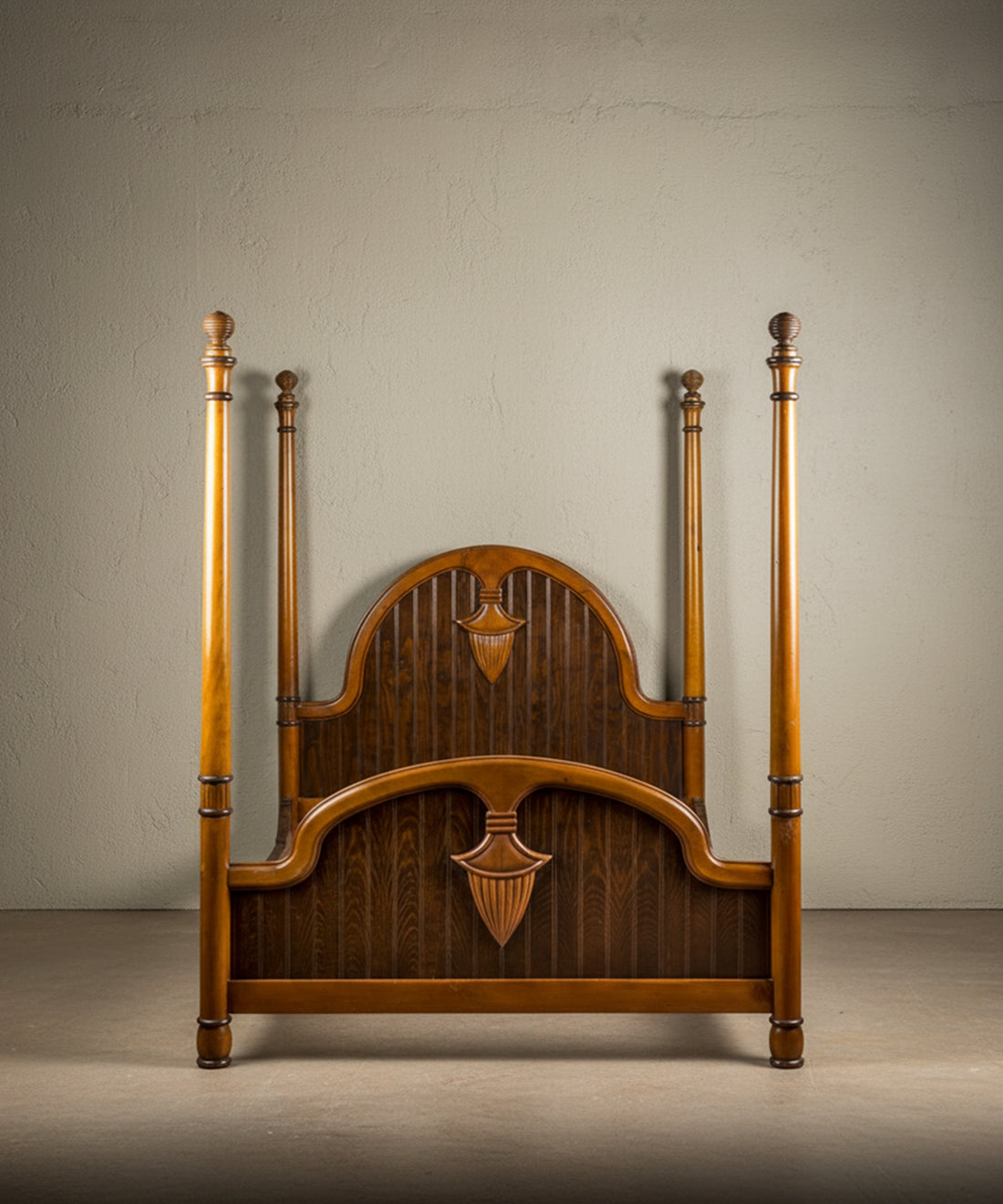 Vista frontal de cama de cuatro postes en madera maciza con paneles arqueados y postes torneados sobre fondo neutro.