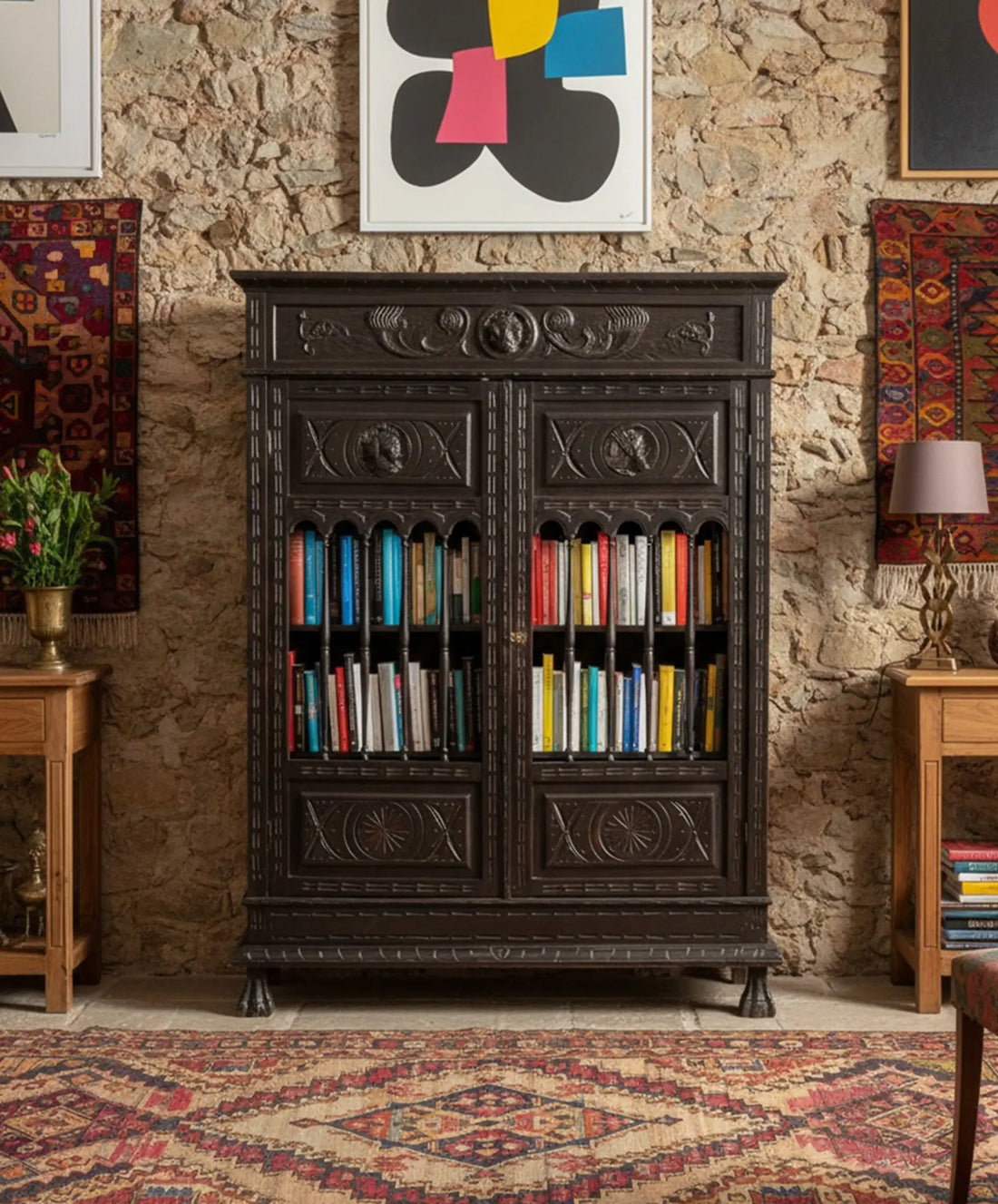Librería antigua ebonizada en interior bohemio con paredes de piedra rústica kilims persas y arte contemporáneo — Antique Arte y Decoración