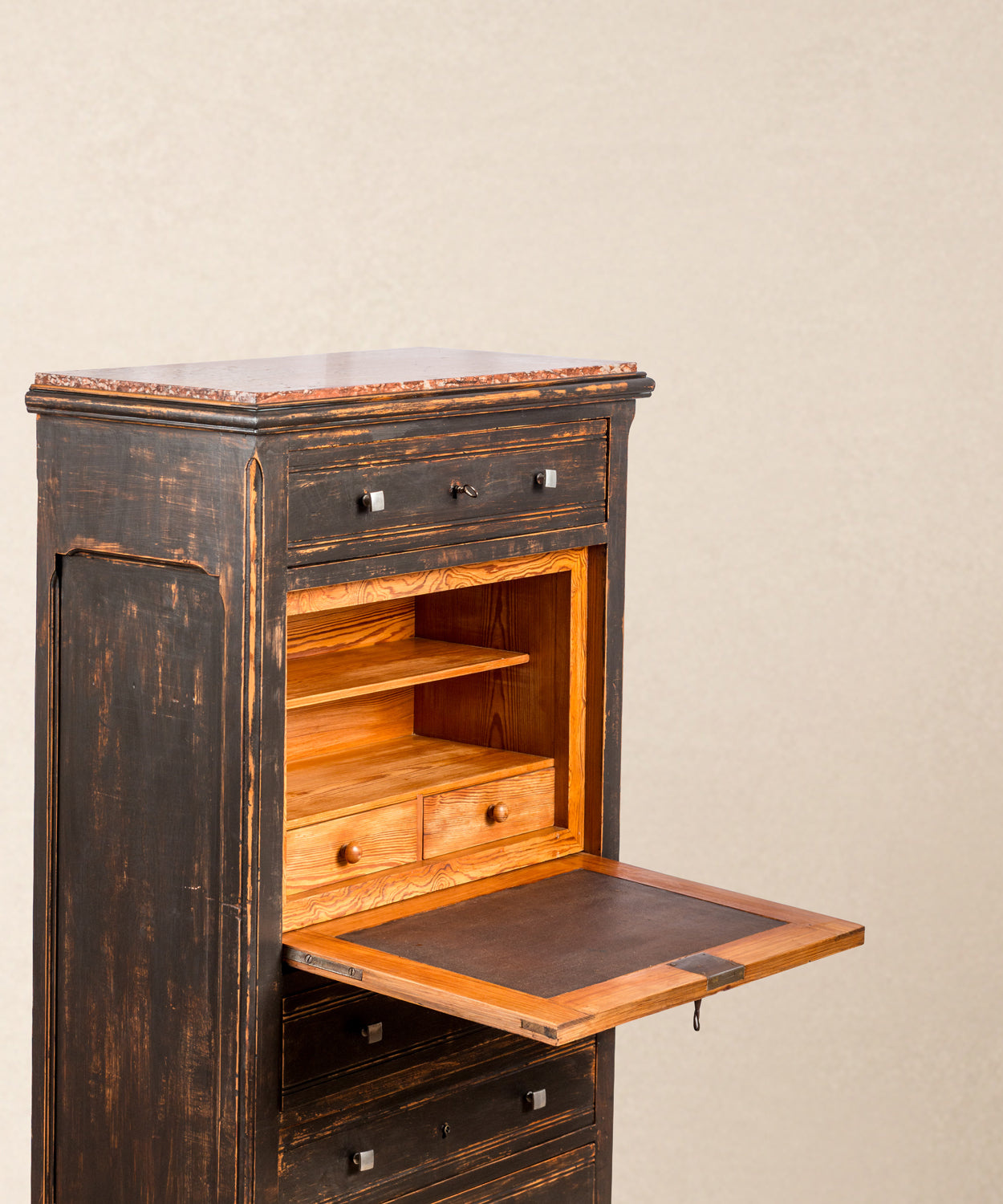 Primer plano del escritorio interior del secreter, estantes y cajoncitos de madera natural pulida.