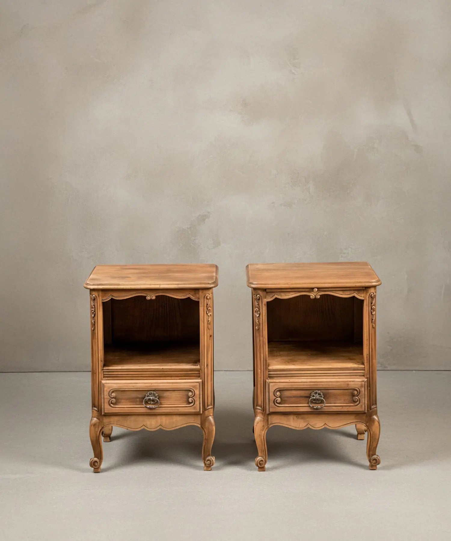 Pareja de mesitas de noche estilo Luis XV en madera de roble natural, vista frontal simétrica.