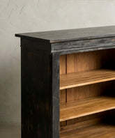 Primer plano de la moldura y el acabado decapado negro sobre madera maciza.