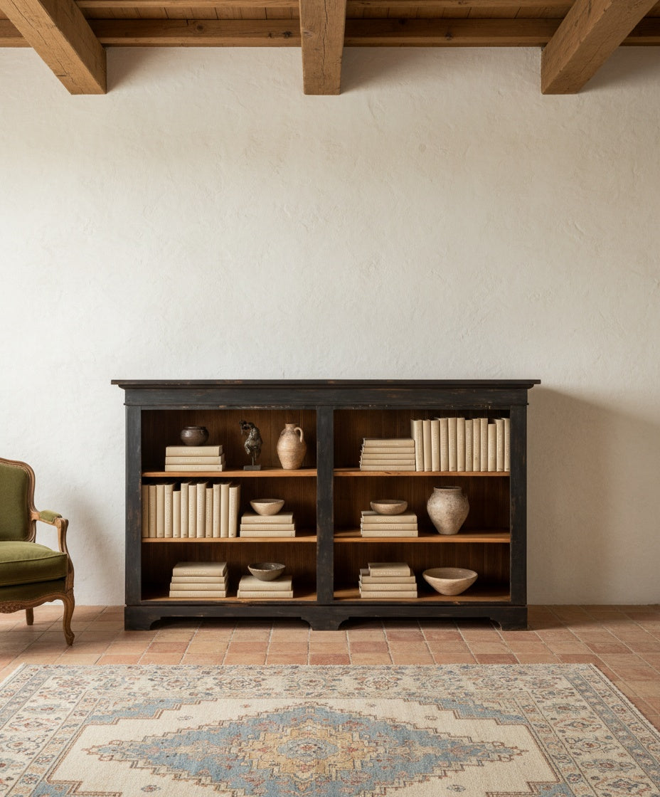 Librería Aquitaine decorada con libros y cerámicas en un salón de estilo mediterráneo.