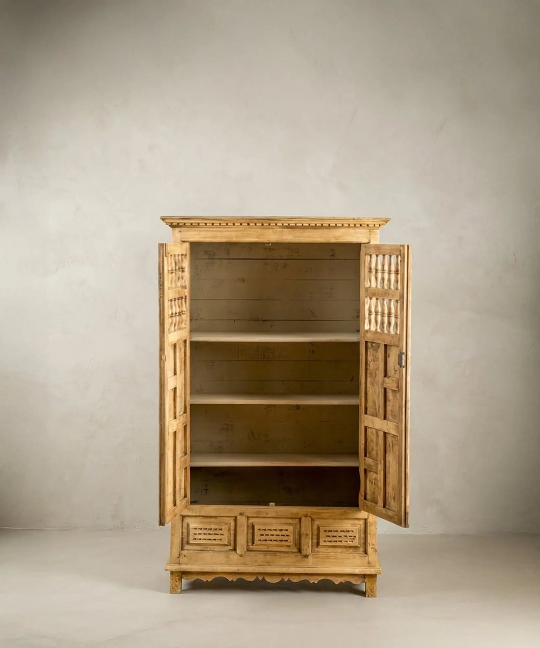 Interior pintado en color crema con baldas en armario de madera natural lavada.