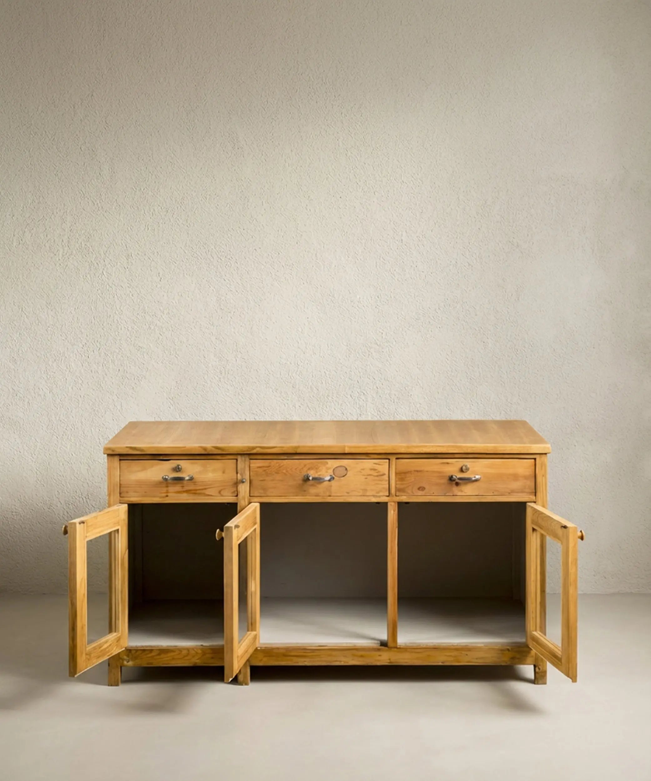Mueble isla de madera con puertas acristaladas abiertas mostrando un amplio interior de almacenaje.