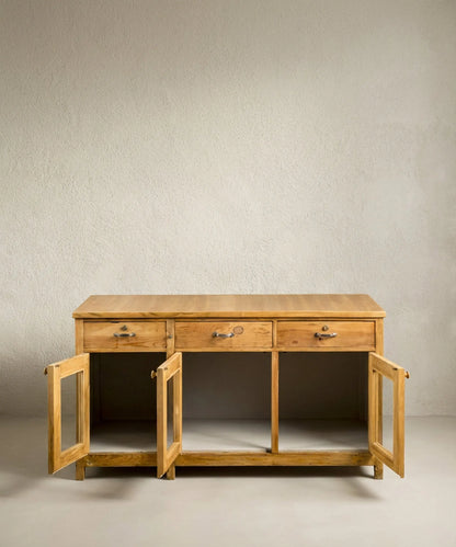 Mueble isla de madera con puertas acristaladas abiertas mostrando un amplio interior de almacenaje.