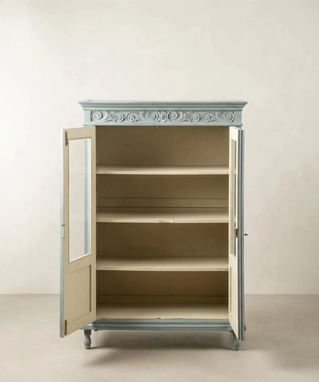 Interior de la vitrina azul provenzal mostrando tres estantes en tono crema.