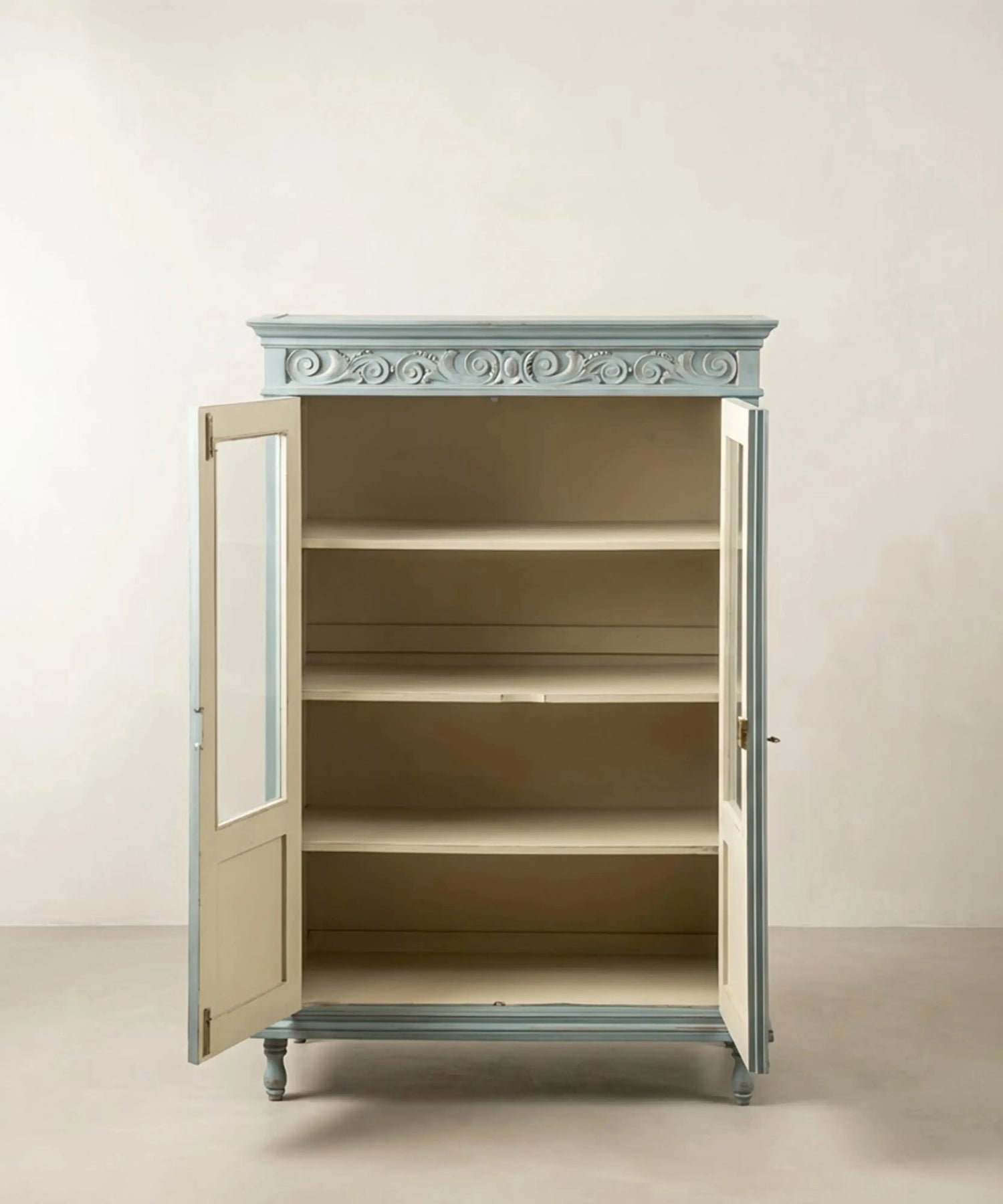 Interior de la vitrina azul provenzal mostrando tres estantes en tono crema.