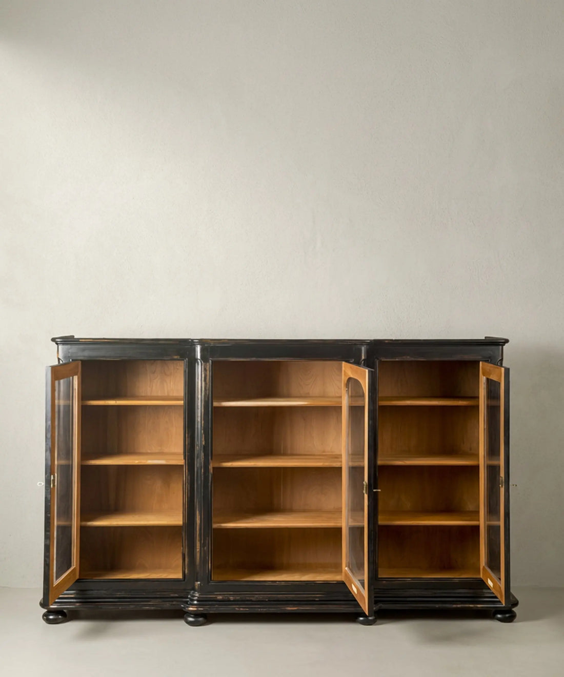 Vitrina con puertas abiertas mostrando los estantes de madera natural clara y su amplio espacio de almacenamiento.