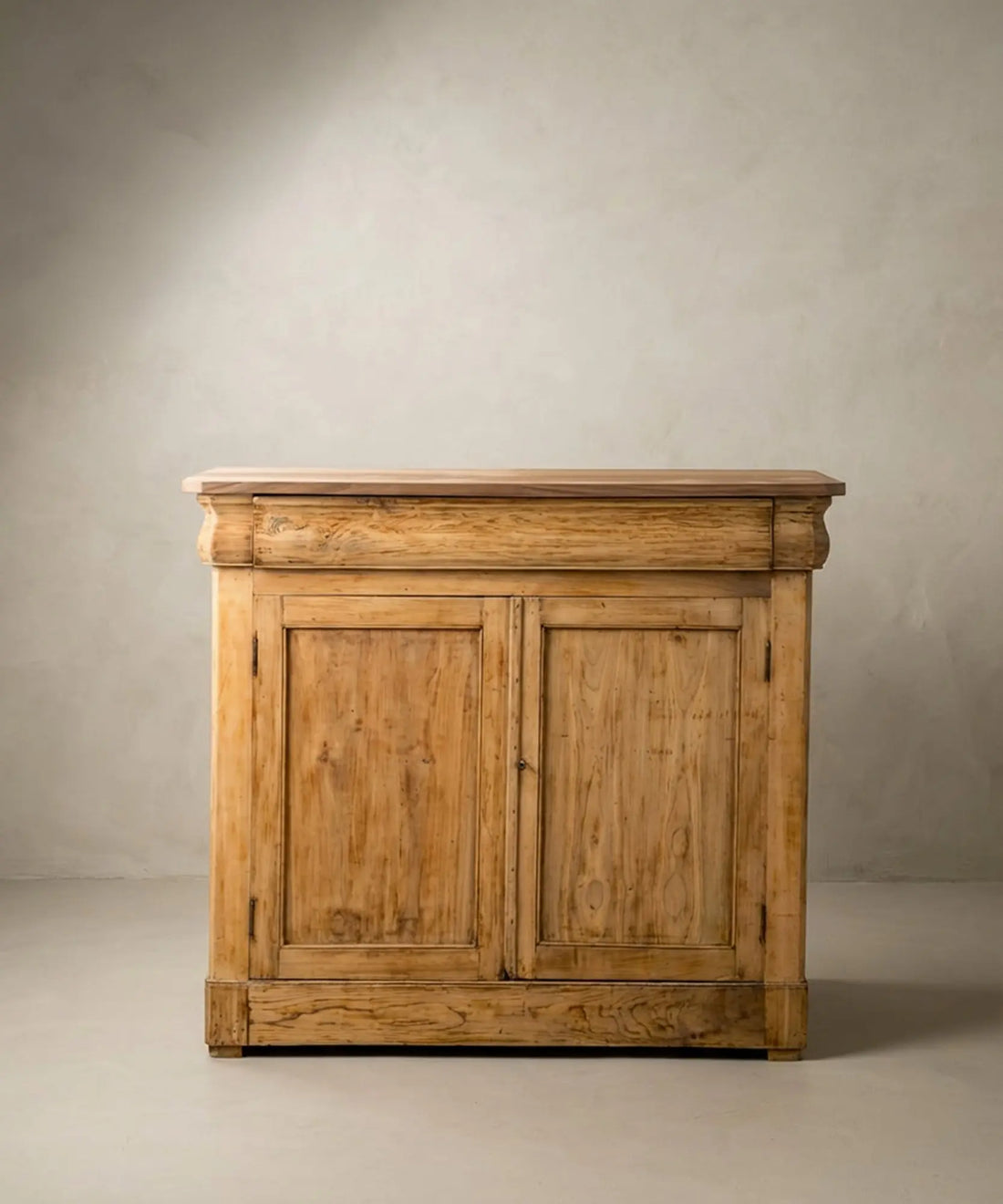 Aparador antiguo de madera clara estilo Luis Felipe con dos puertas y cajón superior integrado.