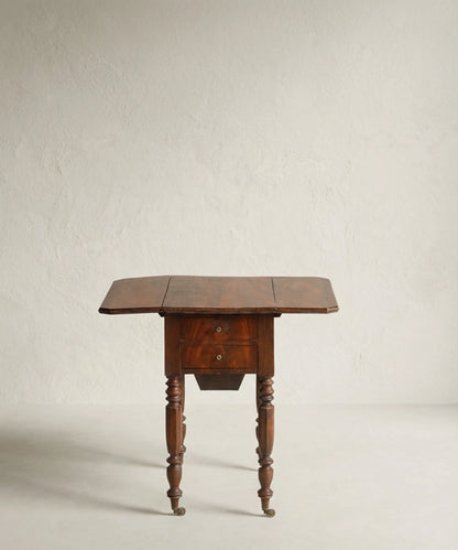 Mesa auxiliar de madera de caoba con alas laterales abatibles desplegadas.