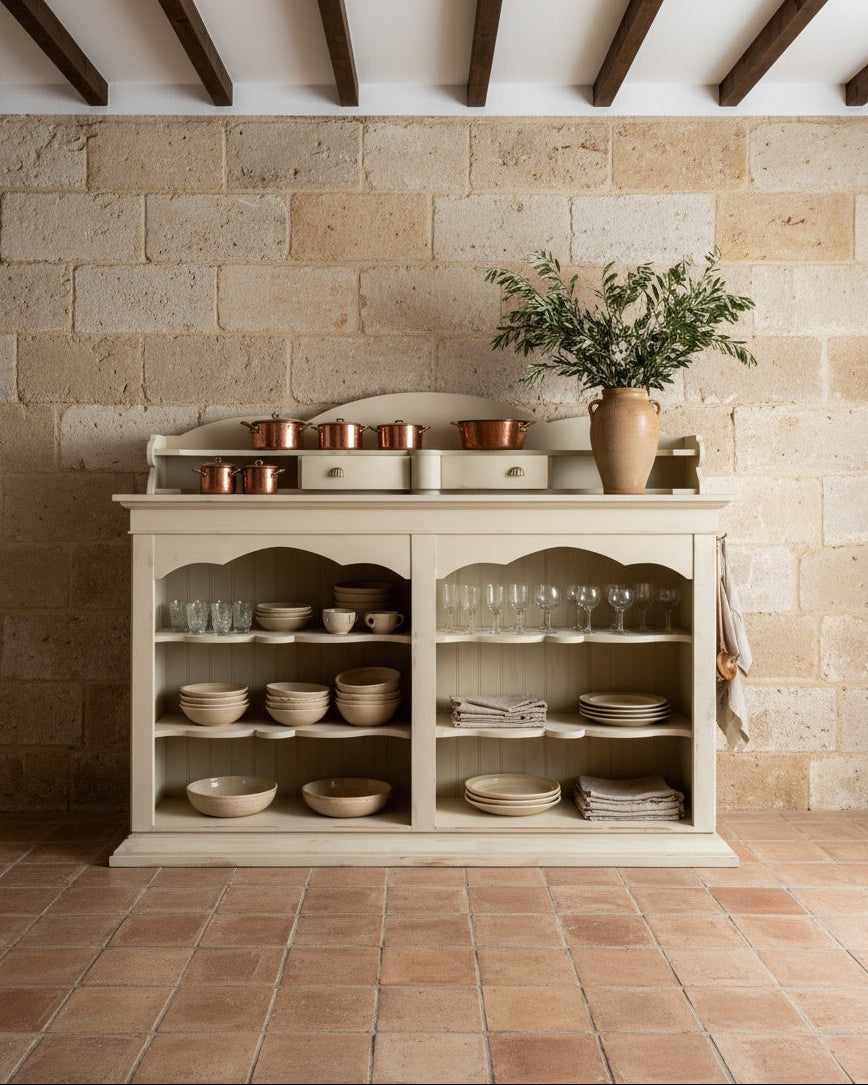 Mueble aparador rústico francés frente a pared de piedra natural, resaltando su estilo campestre elegante.
