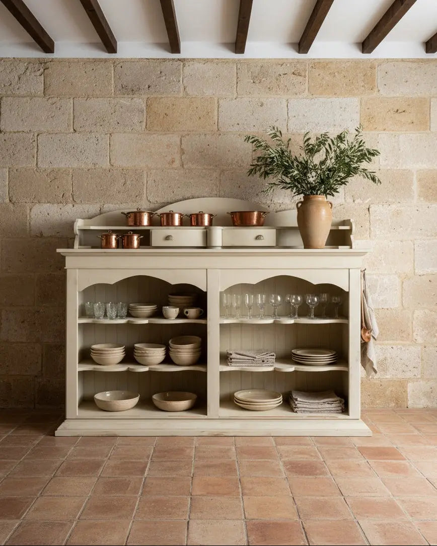 Mueble aparador rústico francés frente a pared de piedra natural, resaltando su estilo campestre elegante.
