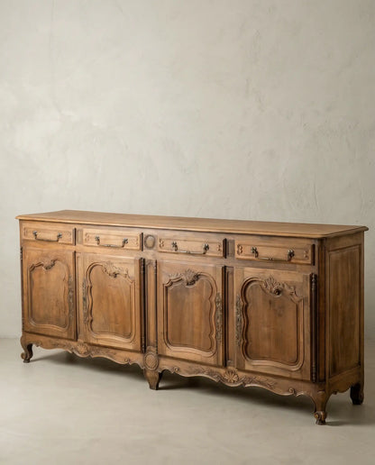 Vista diagonal de mueble enfilade vintage con patas curvas y madera cruda.