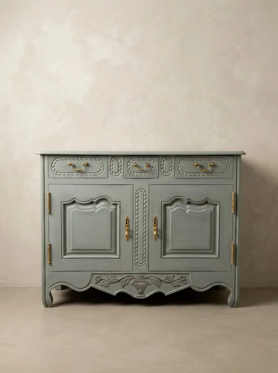 Aparador de estilo provenzal francés en color azul bruma con tallas florales y herrajes de latón.