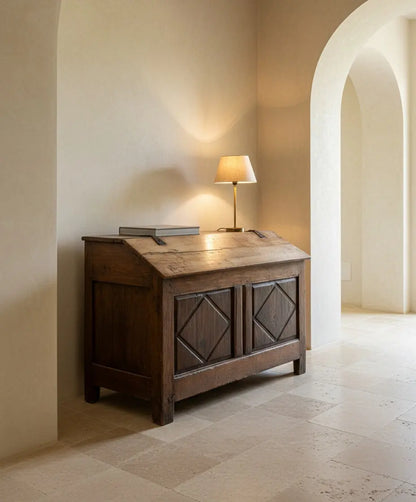 Vista frontal en ángulo de arca  antigua de madera con tapa inclinada y tallas de rombos.