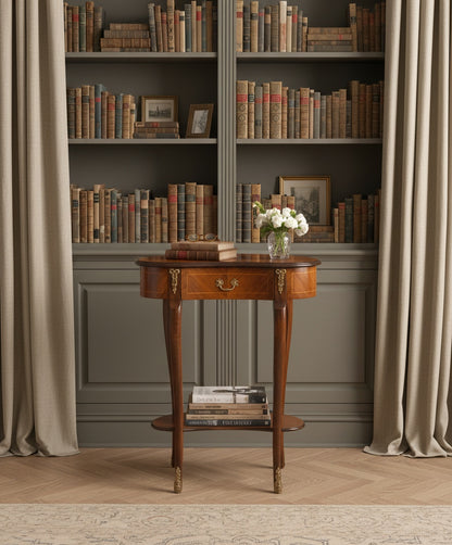 Mesa auxiliar decorada con libros y flores en un ambiente de biblioteca clásica con estanterías y cortinas.