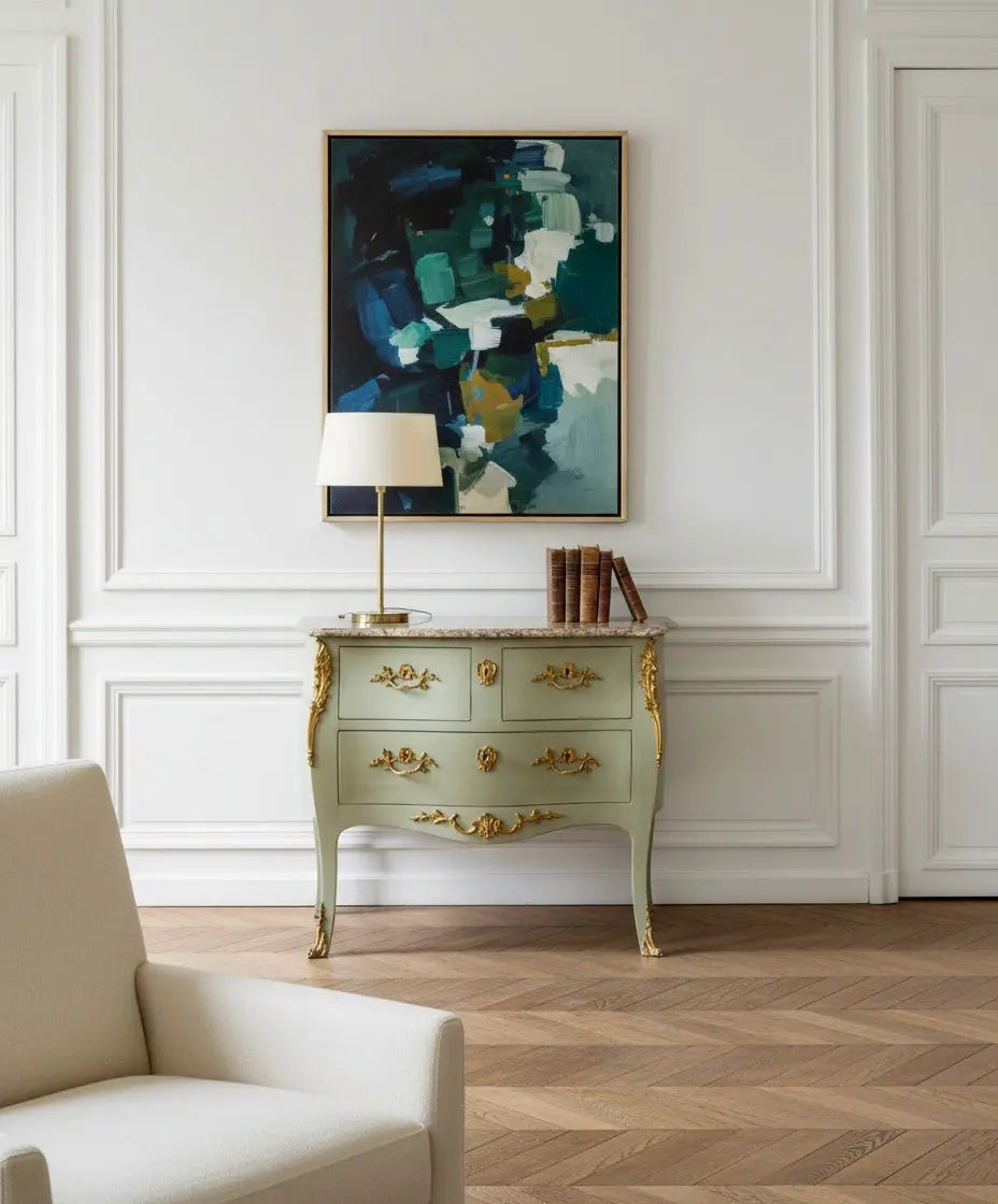 Salón elegante con cómoda antigua Luis XV verde y mármol junto a un cuadro abstracto contemporáneo.