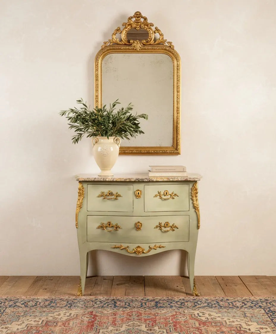 Salón elegante con cómoda antigua Luis XV verde y mármol junto a un cuadro abstracto contemporáneo.