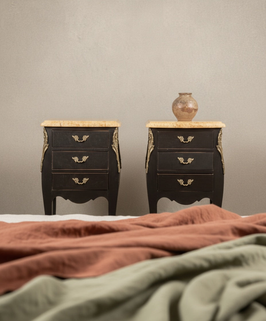 Pareja de mesillas de noche francesas estilo Luis XV en color negro mate con tres cajones y sobres de mármol.
