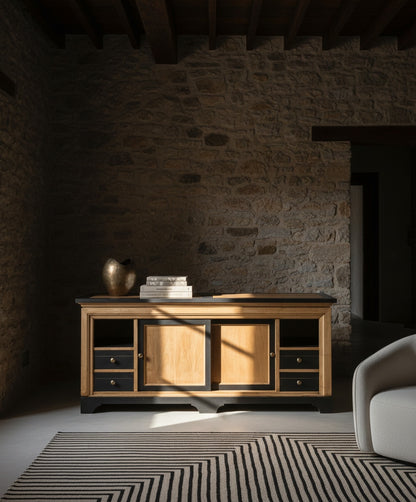 Aparador Lumière situado frente a una pared de piedra original con decoración minimalista y luz natural.