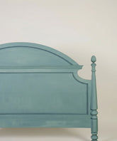 Detalle de la moldura superior arqueada y acabado mate del cabecero vintage
