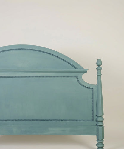 Detalle de la moldura superior arqueada y acabado mate del cabecero vintage
