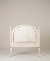 Vista frontal del cabecero estilo gustaviano con forma de arco y remates en los postes