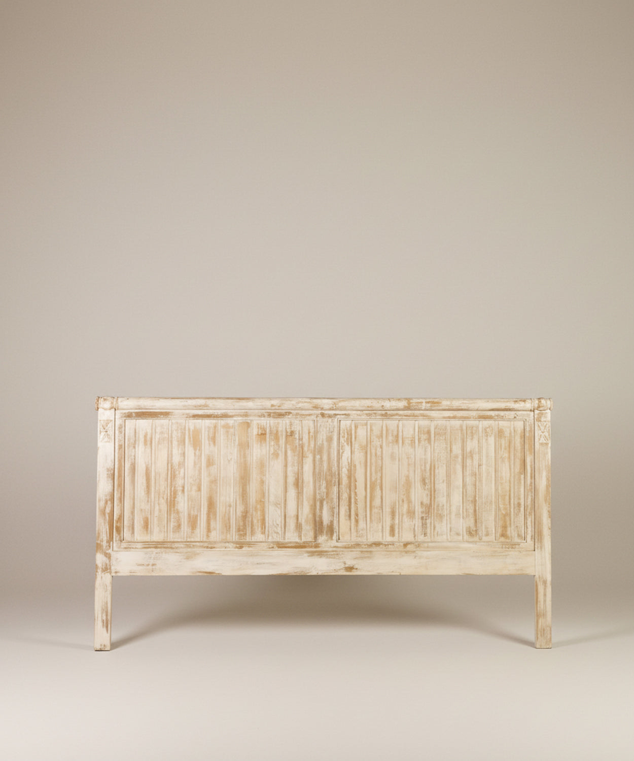 Vista frontal de cabecero ancho de madera lavada con diseño de lamas verticales