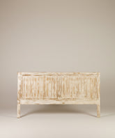 Vista frontal de cabecero ancho de madera lavada con diseño de lamas verticales