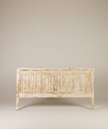 Vista frontal de cabecero ancho de madera lavada con diseño de lamas verticales