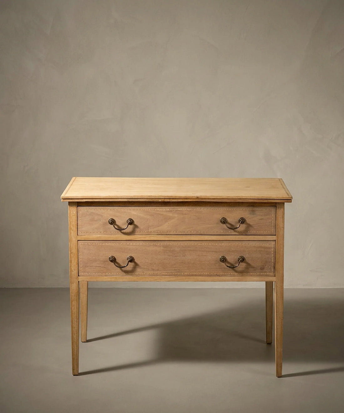 Cómoda antigua pequeña de dos cajones en madera lavada natural estilo neoclásico.