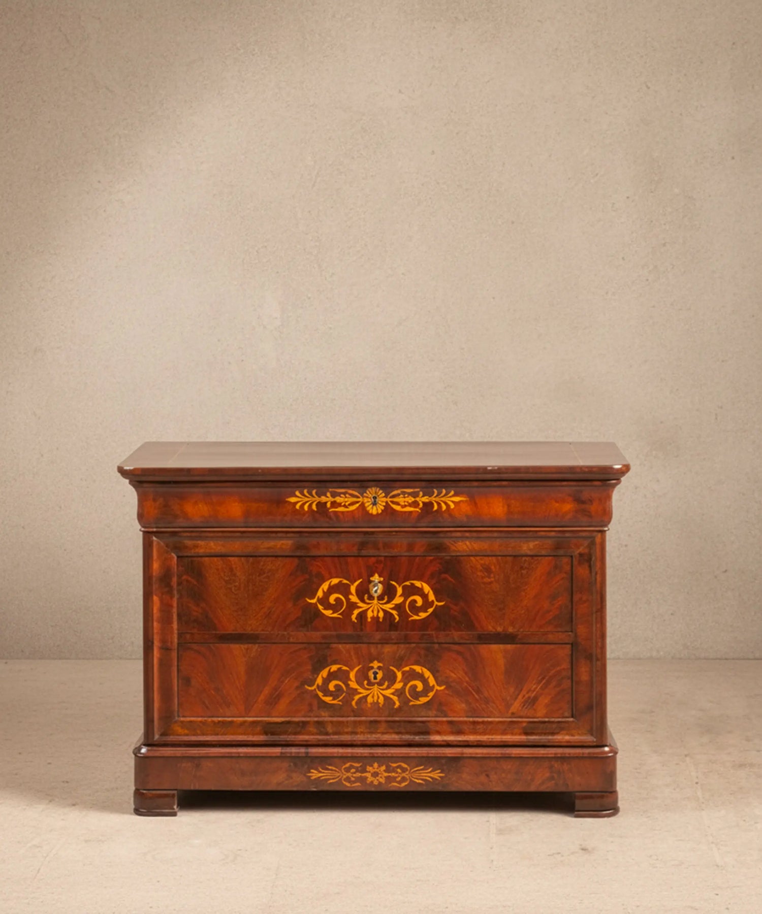 Cómoda antigua estilo imperio en madera de caoba de pluma con marquetería.