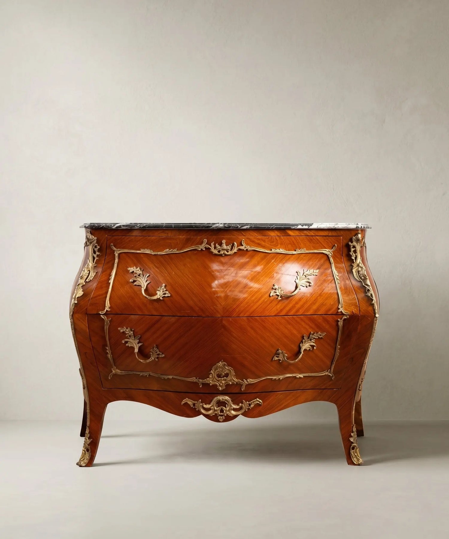 Gran cómoda bombé de estilo Luis XV en madera de palisandro con bronces dorados y tapa de mármol.