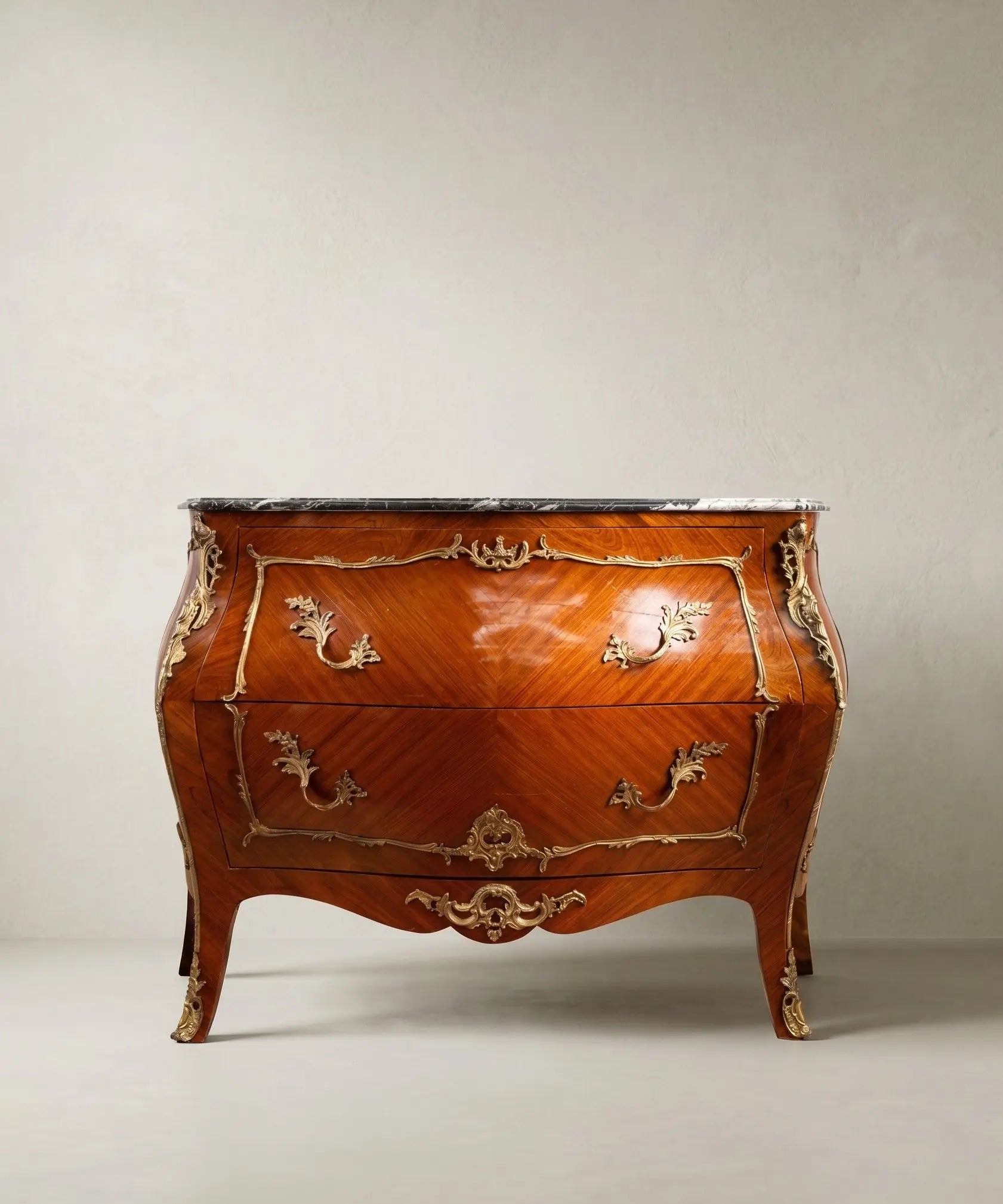 Gran cómoda bombé de estilo Luis XV en madera de palisandro con bronces dorados y tapa de mármol.