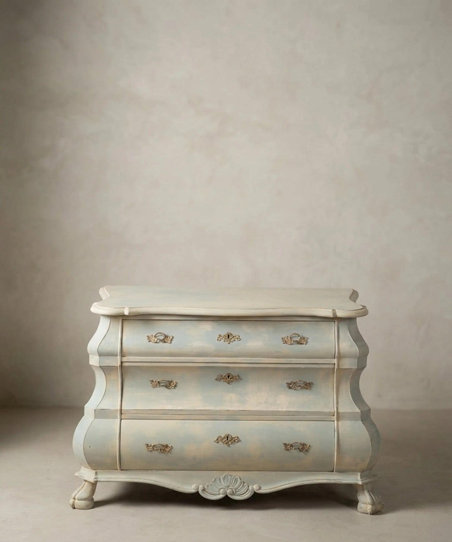 Cómoda baja vintage estilo bombé holandés pintada en azul claro y beige con patas de garra.