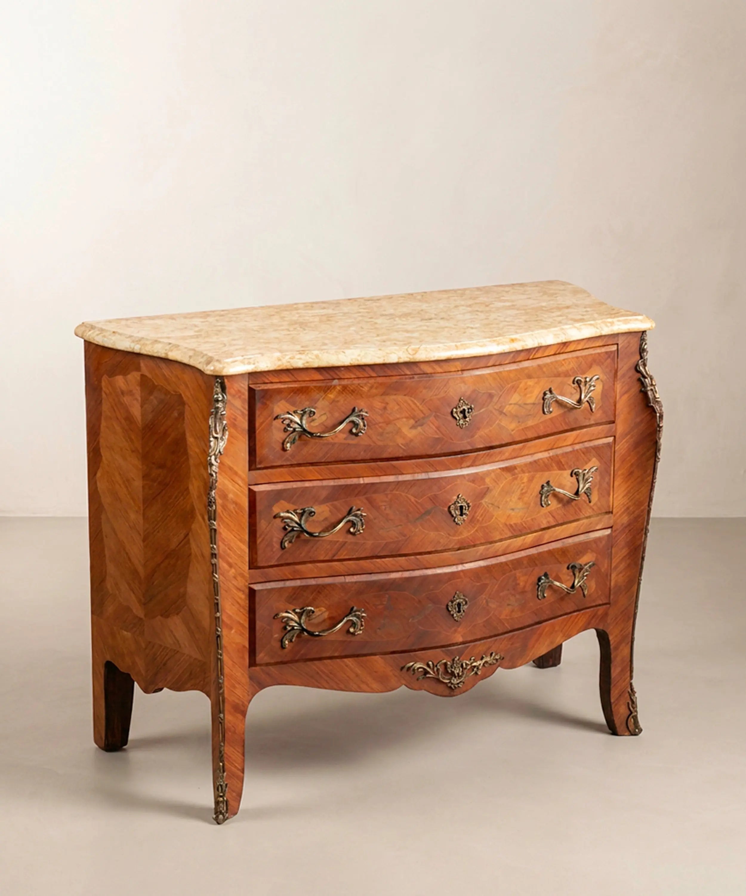 Cómoda panzuda estilo Luis XV de tres cajones con marquetería, bronces y tapa de mármol.