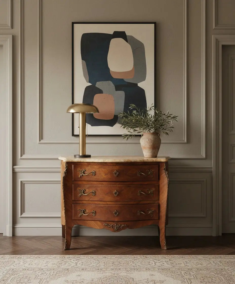Salón contemporáneo con cómoda antigua bombé Luis XV de marquetería y mármol ocre bajo cuadro abstracto.