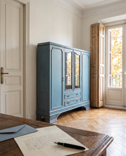Librería vitrina azul decapé en salón con suelo de espiga y contraventanas de madera — Antique Arte y Decoración