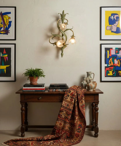 Aplique floral clásico iluminando una consola de madera en un salón con decoración ecléctica y moderna.