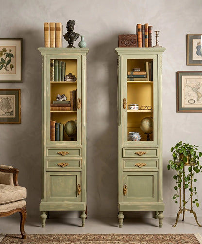 Pareja de vitrinas verde salvia estilo Luis XVI en salón clásico con libros y láminas — Antique Arte y Decoración