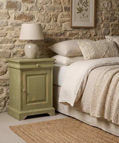Mesita de noche vintage de madera pintada en verde salvia con acabado decapado estilo shabby chic.